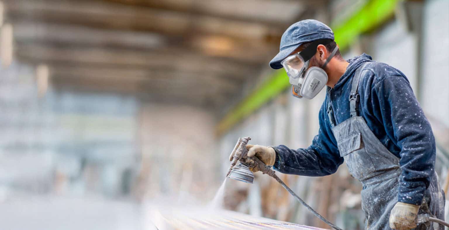 Aircraft parts manufacturing worker using spray gun in factory, industrial craftsmanship, precision workshop, skilled labor, manufacturing technical work, AirGearPro safety gear and tools, factory production scene.